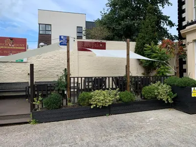 a fence with plants in front of a building at Beech Mount Hotel - Free Parking in Liverpool