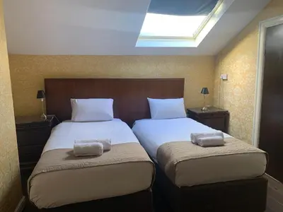 a bedroom with two beds and a skylight at Beech Mount Hotel - Free Parking in Liverpool