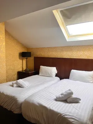 a bedroom with a large bed with two towels on it at Beech Mount Hotel - Free Parking in Liverpool
