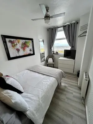 a bedroom with a large white bed and a window at Sandford Promenade in Blackpool