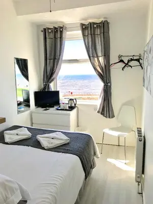 a bedroom with a bed and a view of the ocean at Sandford Promenade in Blackpool