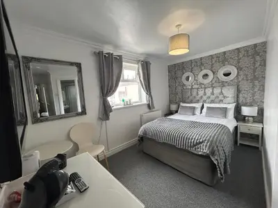 a bedroom with a bed and a sink and a mirror at Sandford Promenade in Blackpool