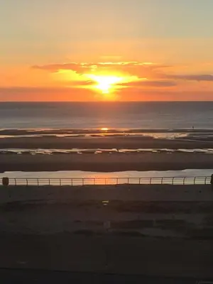 a sunset on the beach with the sun setting over the ocean at Sandford Promenade in Blackpool