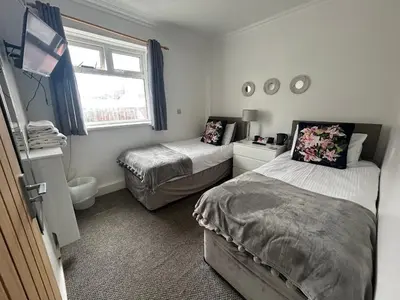 a bedroom with two beds and a window at Sandford Promenade in Blackpool