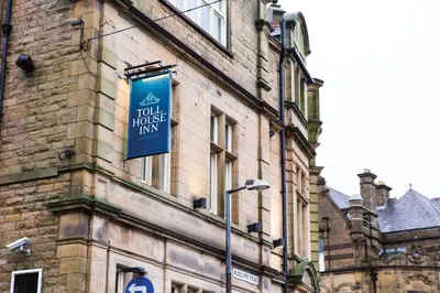 a building with a blue sign on the side of it at Toll House Inn in Lancaster