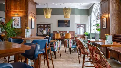 a restaurant with wooden tables and blue chairs at Toll House Inn in Lancaster
