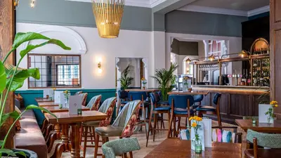 a restaurant with tables and chairs and a bar at Toll House Inn in Lancaster