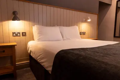 a hotel room with a large bed with white pillows at Hartwood Hall by Greene King Inns in Chorley