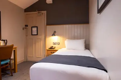 a bedroom with a bed and a desk with a lamp at Hartwood Hall by Greene King Inns in Chorley