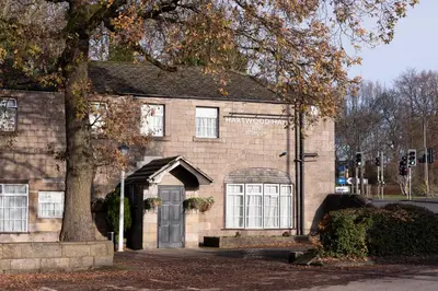a brick building with a door and a tree at Hartwood Hall by Greene King Inns in Chorley