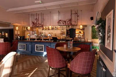 a bar with chairs and a table in a restaurant at Hartwood Hall by Greene King Inns in Chorley