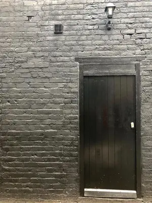 a black door on a brick wall with a street light at Luxury Apartment in Blackpool