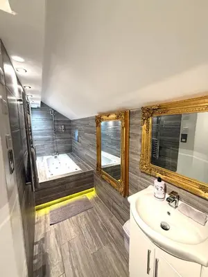 a bathroom with a tub and a sink and a mirror at Luxury Apartment in Blackpool