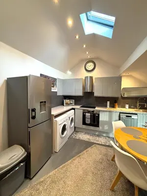 a kitchen with stainless steel appliances and a table at Luxury Apartment in Blackpool