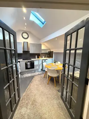 a kitchen with a table and a clock on the ceiling at Luxury Apartment in Blackpool