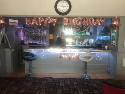 a bar with a happy birthday sign and two bar stools at Lexham Hotel in Blackpool