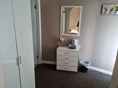 a bedroom with a white dresser and a mirror at Lexham Hotel in Blackpool