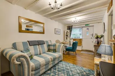 a living room with a couch and a table at Coachhousebungalow in Grange Over Sands