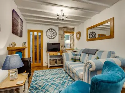 a living room with a couch and a table at Coachhousebungalow in Grange Over Sands