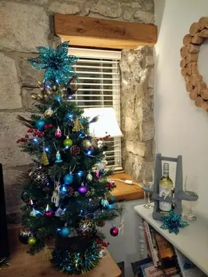 a christmas tree in the corner of a room at Coachhousebungalow in Grange Over Sands