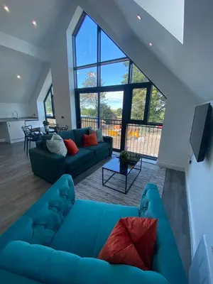 a living room with a blue couch and a large window at Hotel Tia in Liverpool
