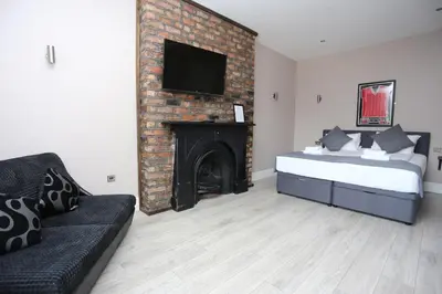 a bedroom with a bed and a fireplace with a tv at Hotel Tia in Liverpool