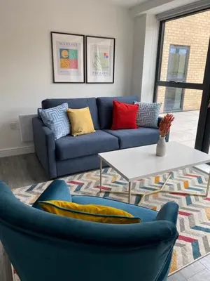 a living room with a blue couch and a table at Hotel Tia in Liverpool