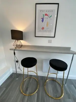 two black and gold stools sitting next to a counter at Hotel Tia in Liverpool