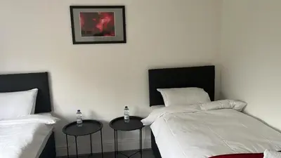 two beds sitting next to each other in a bedroom at Hotel Tia in Liverpool