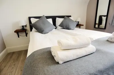 a large white bed with two pillows on it at Hotel Tia in Liverpool