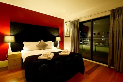 a bedroom with a large bed with two towels on it at Merchant Quarters Apartments in Liverpool