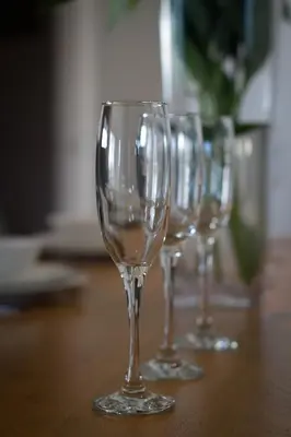 four empty wine glasses sitting on a wooden table at Merchant Quarters Apartments in Liverpool