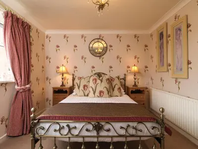 a bedroom with a bed with floral wallpaper at Howarth House in Lytham St Annes