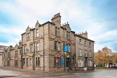 an old stone building on the corner of a street at The Royal Hotel and Bar in Lancaster