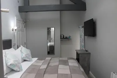 a bedroom with a bed and a tv on the wall at The Royal Hotel and Bar in Lancaster