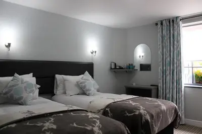 a hotel room with two beds and a window at The Royal Hotel and Bar in Lancaster