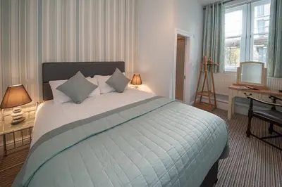 a bedroom with a bed and a desk and a television at The Royal Hotel and Bar in Lancaster