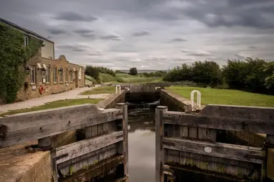 a group of locks in a canal in front of a building at Pyes Mill Hotel Conder Green in Conder Green
