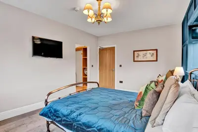a bedroom with a bed with a blue comforter at Pyes Mill Hotel Conder Green in Conder Green
