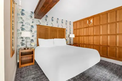 a bedroom with a large white bed and blue and white wallpaper at Thurnham Hall Resort in Cockerham