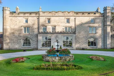 a large stone building with a fountain in front of it at Thurnham Hall Resort in Cockerham