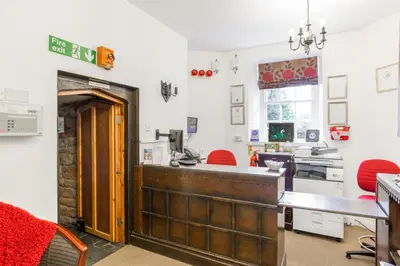 a kitchen with a counter and red chairs in it at Thurnham Hall Resort in Cockerham