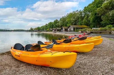 a group of kayaks on the shore of a lake at Pine Lake Resort in Carnforth