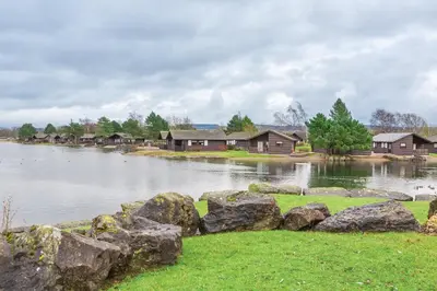 a large body of water with houses and rocks at Pine Lake Resort in Carnforth
