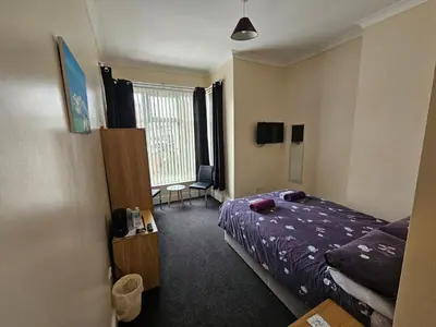 a hotel room with a bed and a window at Bayswater House in Blackpool