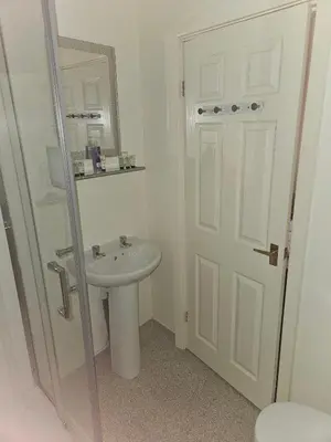 a white bathroom with a sink and a mirror at Bayswater House in Blackpool