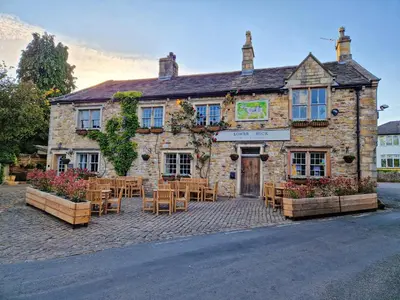 a building with tables and chairs in front of it at The Lower Buck Inn in Clitheroe