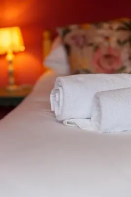 two rolled towels sitting on top of a bed at The Lower Buck Inn in Clitheroe