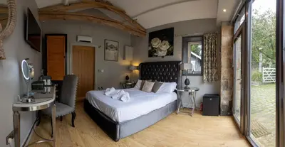 a bedroom with a large bed and a desk and a window at The Lower Buck Inn in Clitheroe
