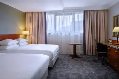 a hotel room with two beds and a desk and a window at Delta Hotels by Marriott Liverpool City Centre in Liverpool